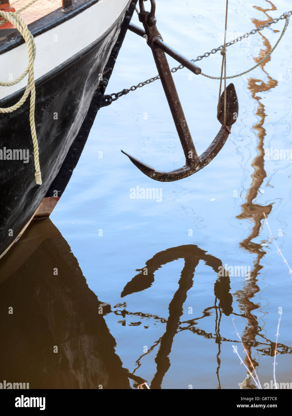 A boat with overhanging anchor and water reflection bug Stock Photo - Alamy