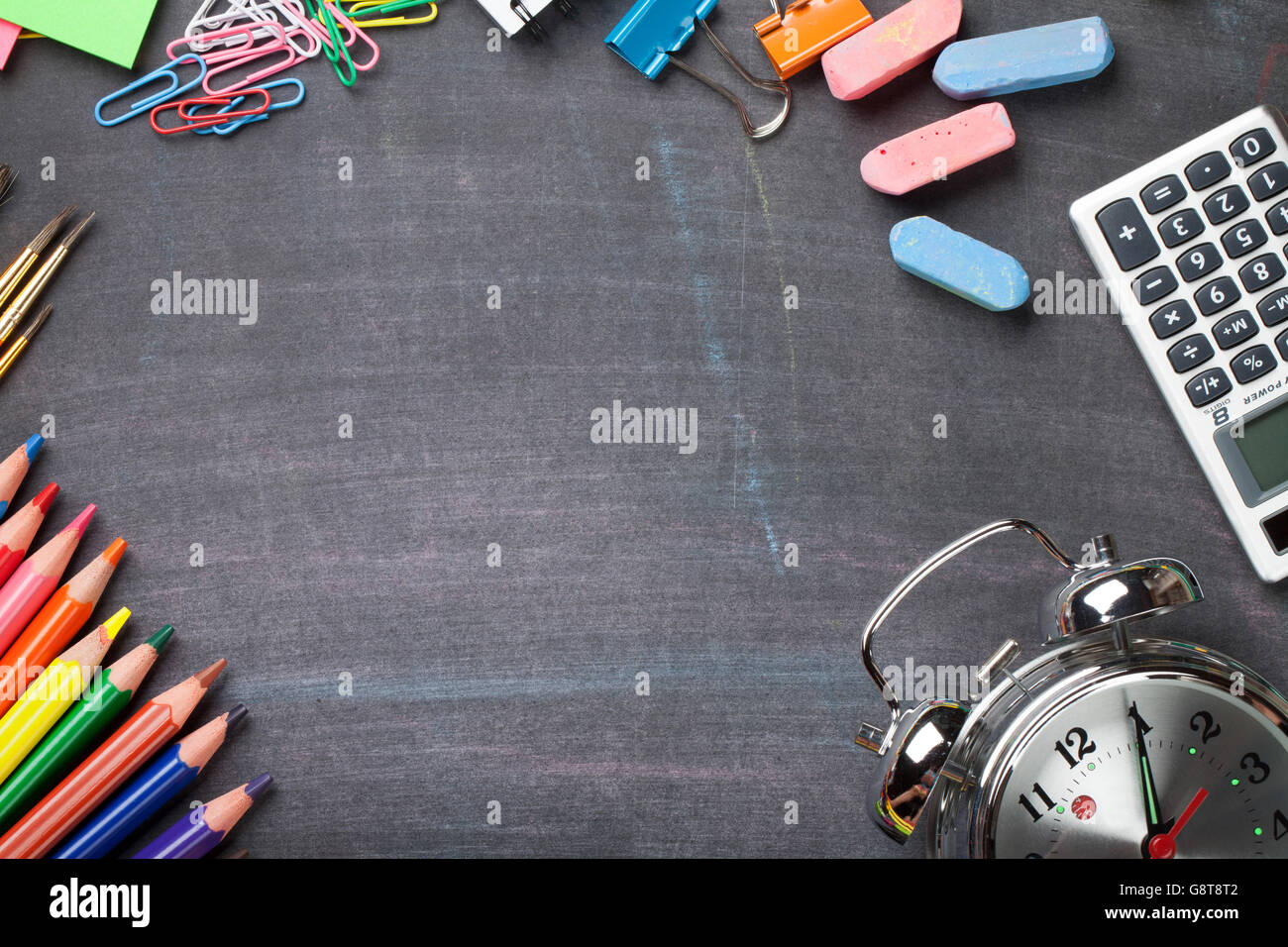 School and office supplies on blackboard background. Top view with copy ...
