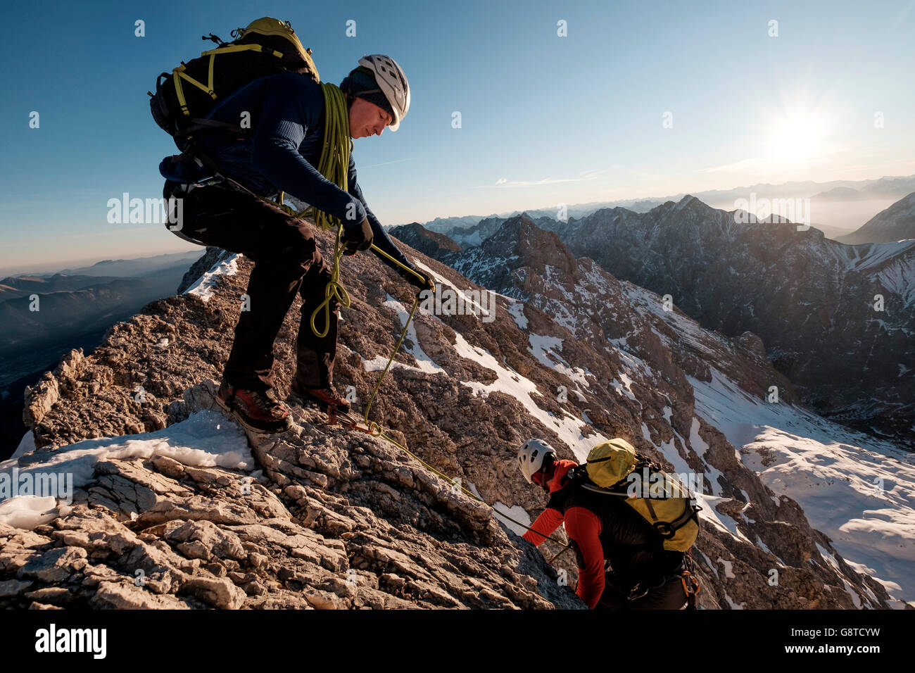 Two mountaineers climbing mountain peak in European Alps Stock Photo