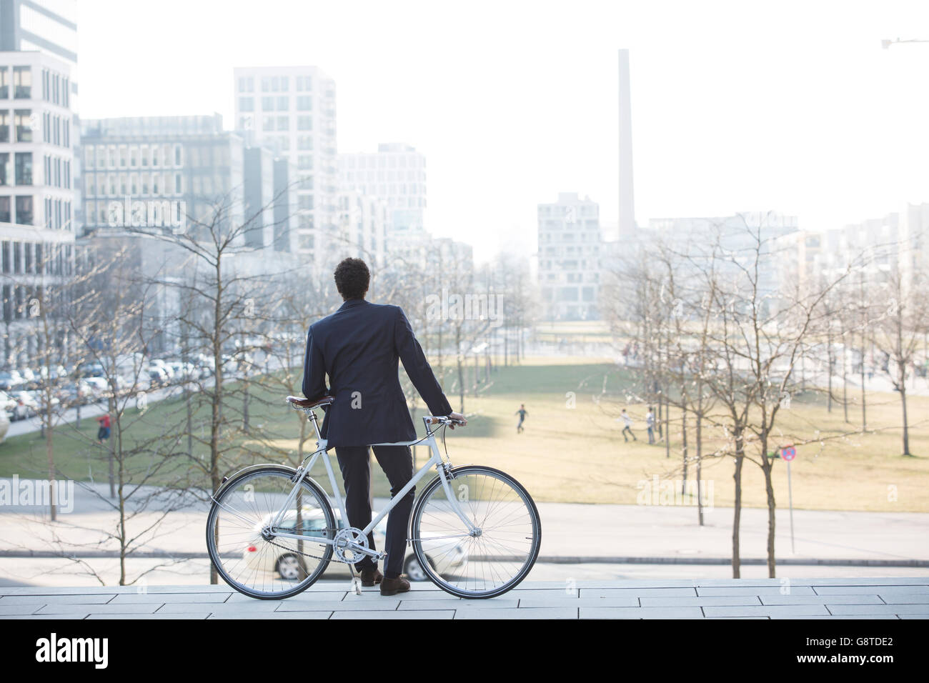 Businessman with bicycle taking a break in city Stock Photo