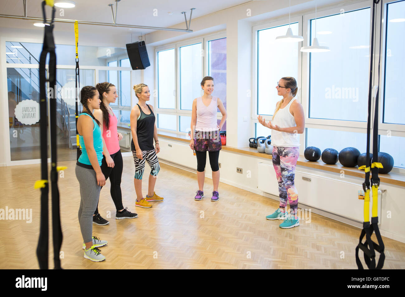 Fitness instructor in health club explains suspension training Stock Photo