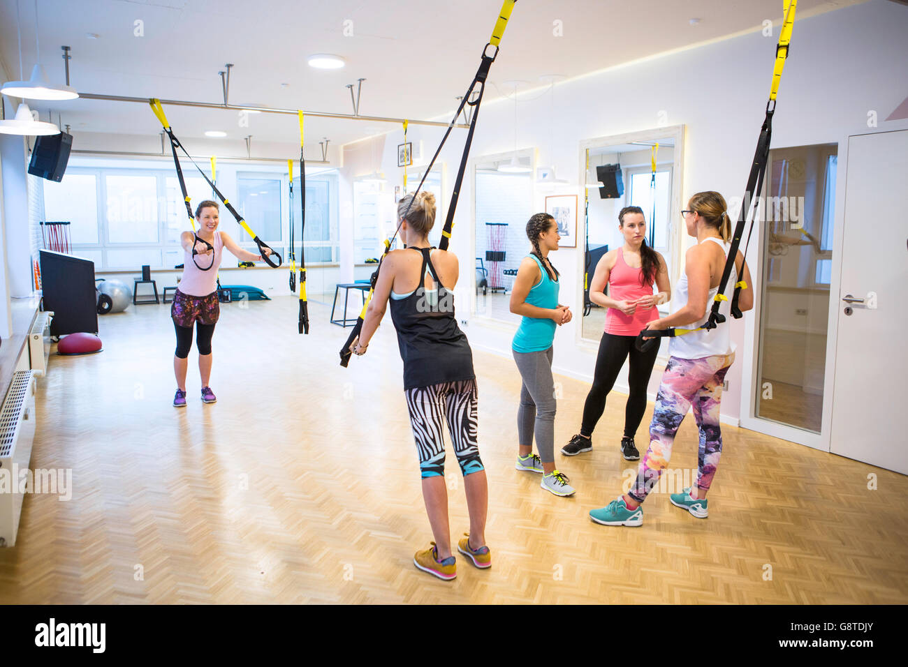 Women in exercise class doing suspension training Stock Photo