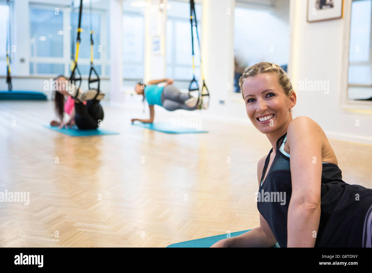 Women in exercise class doing suspension training Stock Photo