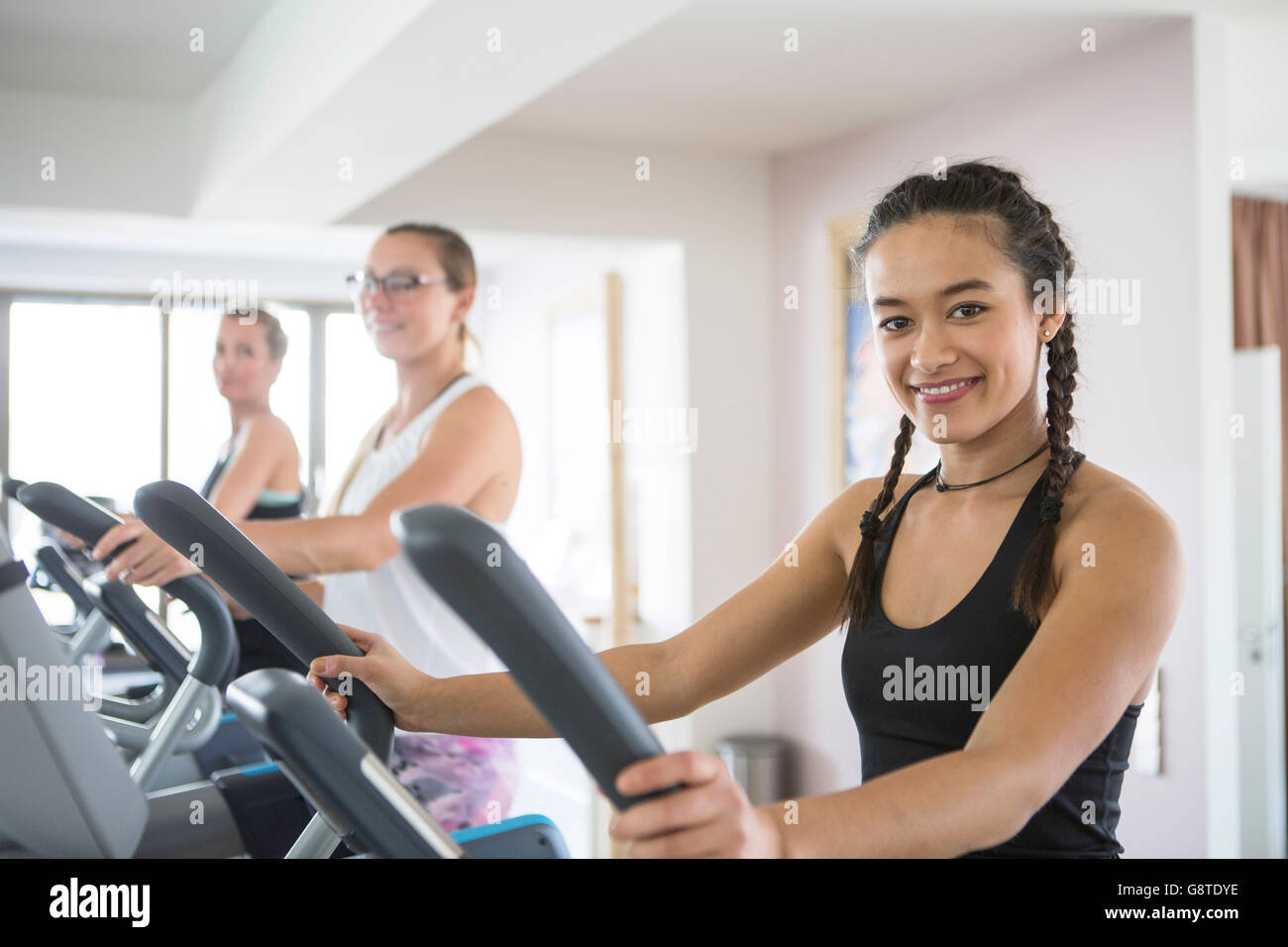 Women exercising on cross trainer in health club Stock Photo