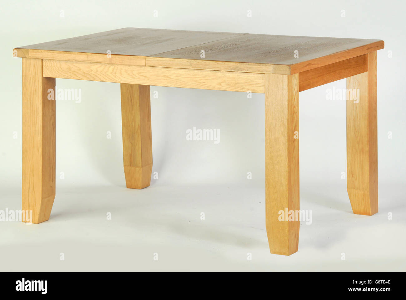 A single wooden dining table on a white background Stock Photo