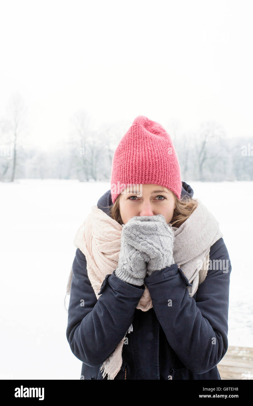 Mid adult woman with knit hat and hands covering mouth Stock Photo