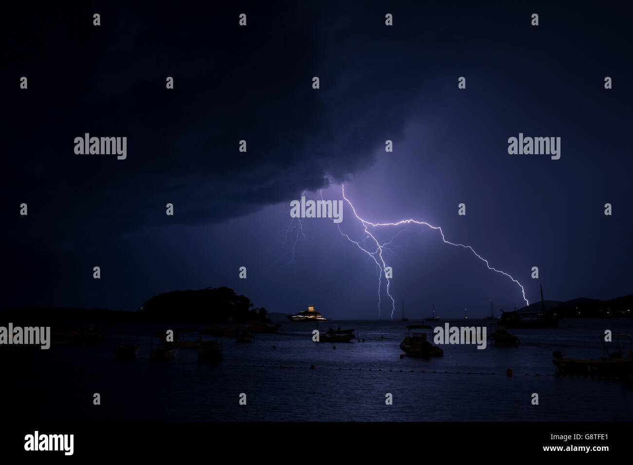 Lightnings in thunderstorm over sea at night Stock Photo