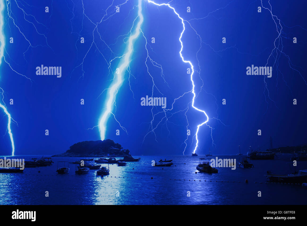 Lightnings in thunderstorm over harbor at night Stock Photo