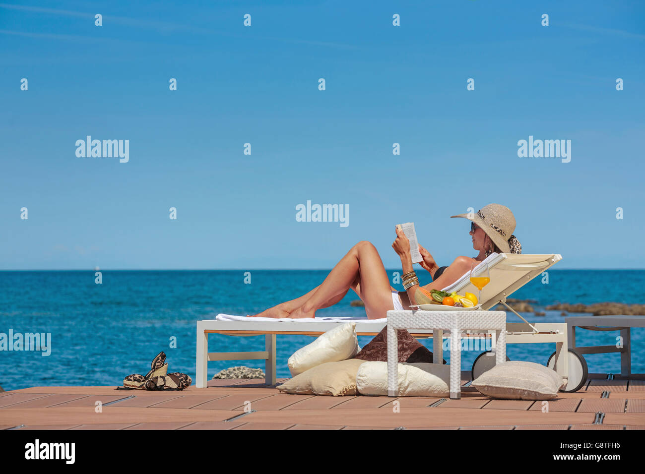 Woman lying on beach chair hi-res stock photography and images - Alamy