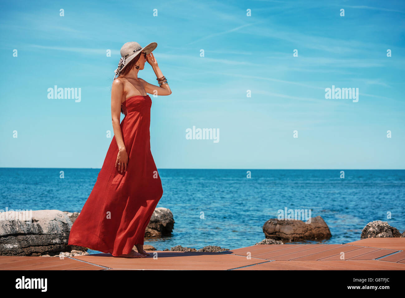 Beautiful woman in red summer dress looking out over ocean Stock Photo - Alamy Beautiful woman in red summer dress looking out over ocean Stock Photo - Alamy