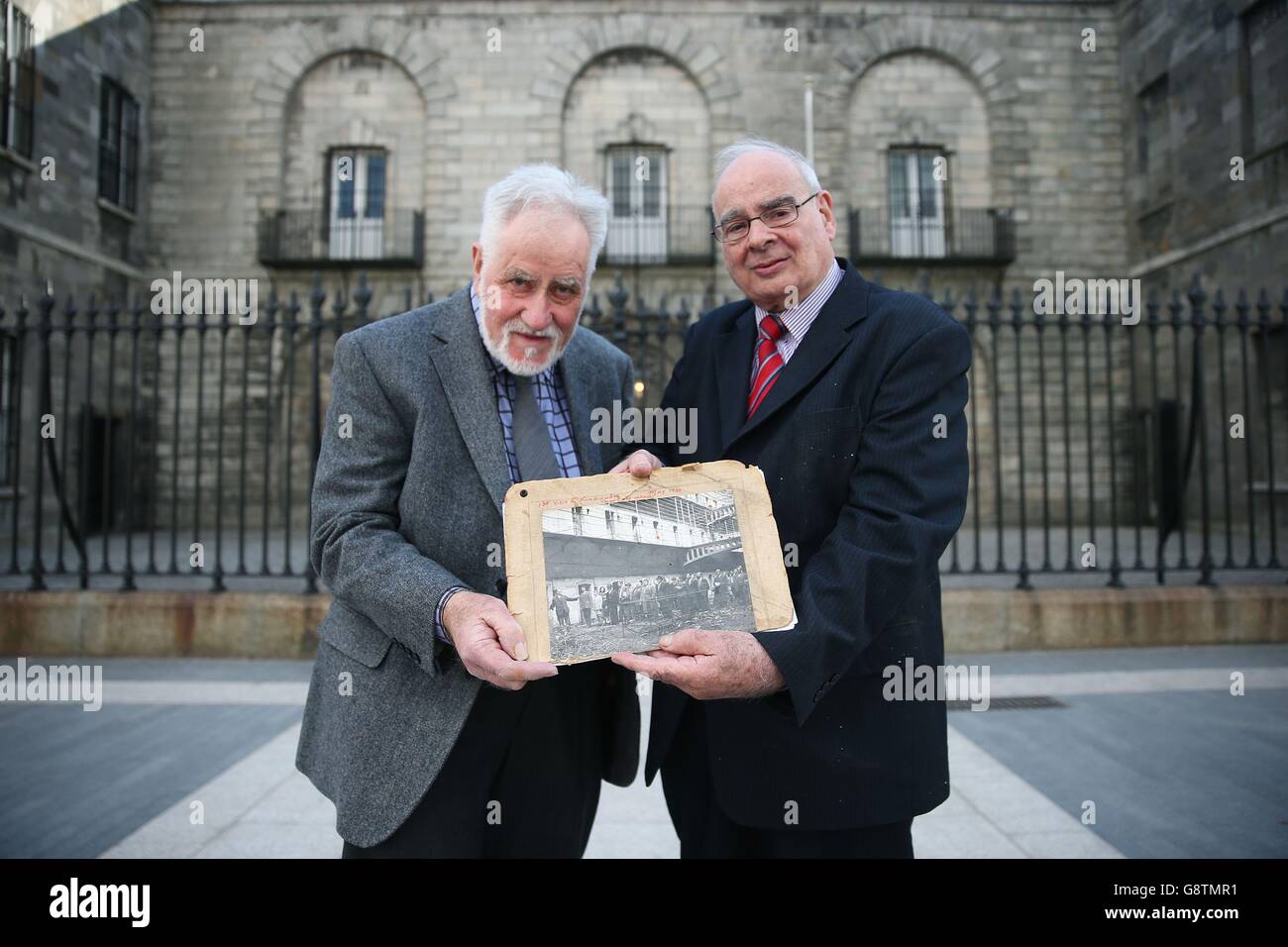 Damien Cassidy (right), chairman of the board of visitors in Kilmainham and one of the original trustees of the Kilmainham Gaol Restoration Committee set up in 1960, and fellow volunteer George Saunders, hold a photograph showing the voluntary workers' first visit to the gaol in May 1960, as they attend a special event in Dublin, Ireland, held to honour the Kilmainham Gaol Restoration Society, the volunteer group which saved the historic prison from dereliction in the 1960s. Stock Photo