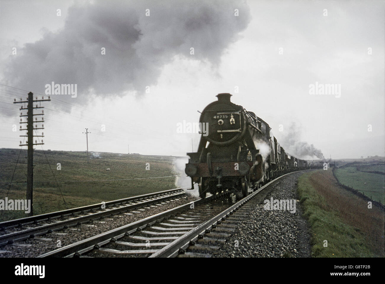 With a banker attached, a Stanier 8F climbs Shap during a rain storm on 27 September 1967. Stock Photo