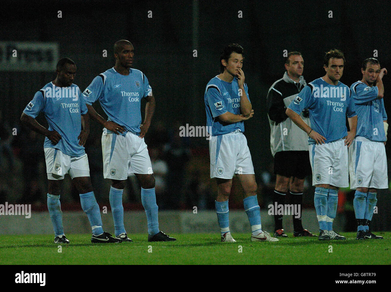 Manchester City players watch from the half way line during the penalty shootout Stock Photo