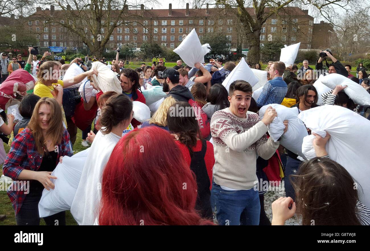 People take part in a mass pillow fight in Kennington park in London, to mark International Pillow Fight Day. Stock Photo