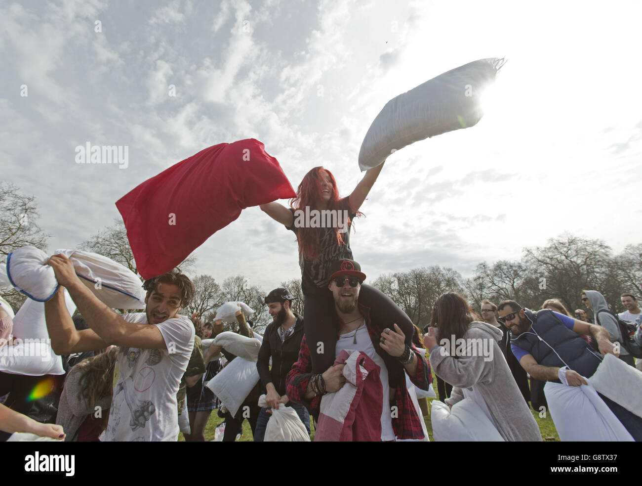 People take part in a mass pillow fight in Kennington Park in London, to mark International Pillow Fight Day. Stock Photo