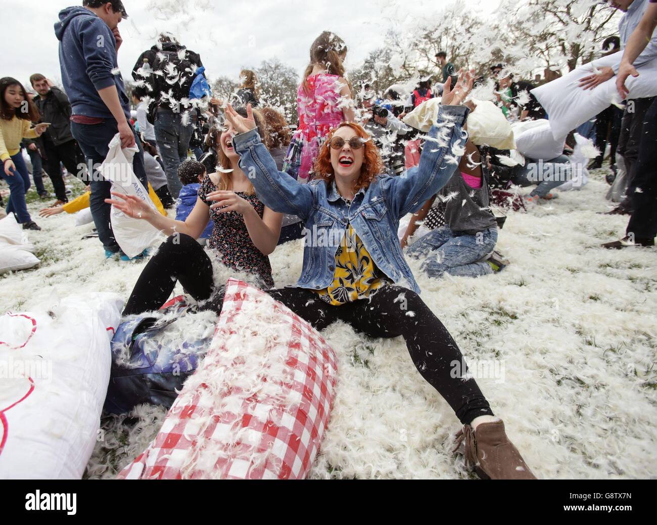People take part in a mass pillow fight in Kennington Park in London, to mark International Pillow Fight Day. Stock Photo