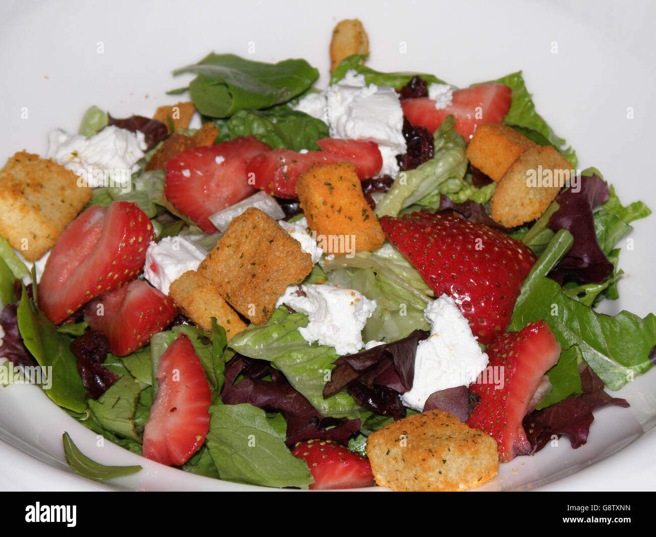 Fresh strawberry salad with goat cheese and croutons. Stock Photo