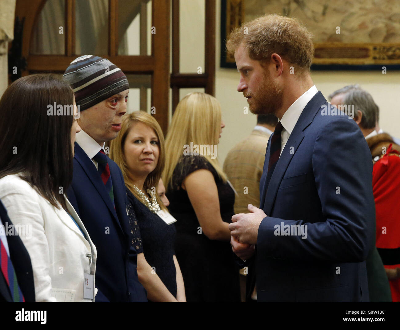 Prince Harry (right) speaks to Martyn Compton(2nd left) a former British soldier from the Household Cavalry Regiment who suffered his injuries after an RPG set his vehicle alight in Afghanistan, at the Lord Mayor's Big Curry Lunch in aid of ABF (Army Benevolent Fund) The Soldier's Charity, at the Guildhall in London. Stock Photo