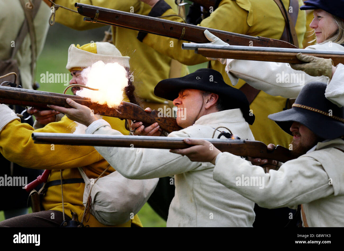 Royalists fire their muskets during a battle against the Parliamentarians as members of The Sealed Knot re-enact the last few hours of the 1645 battle for Basing House, near Basingstoke in Hampshire. Stock Photo
