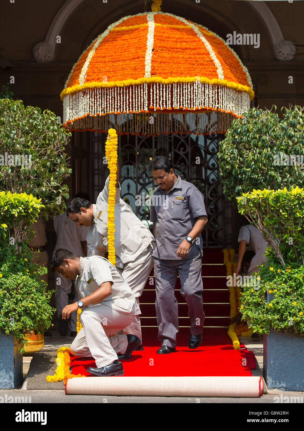 Workers prepare a red carpet for the arrival of the Duke and Duchess of Cambridge at the Taj Mahal Palace hotel in Mumbai, India, on day one of the royal tour to India and Bhutan. Stock Photo