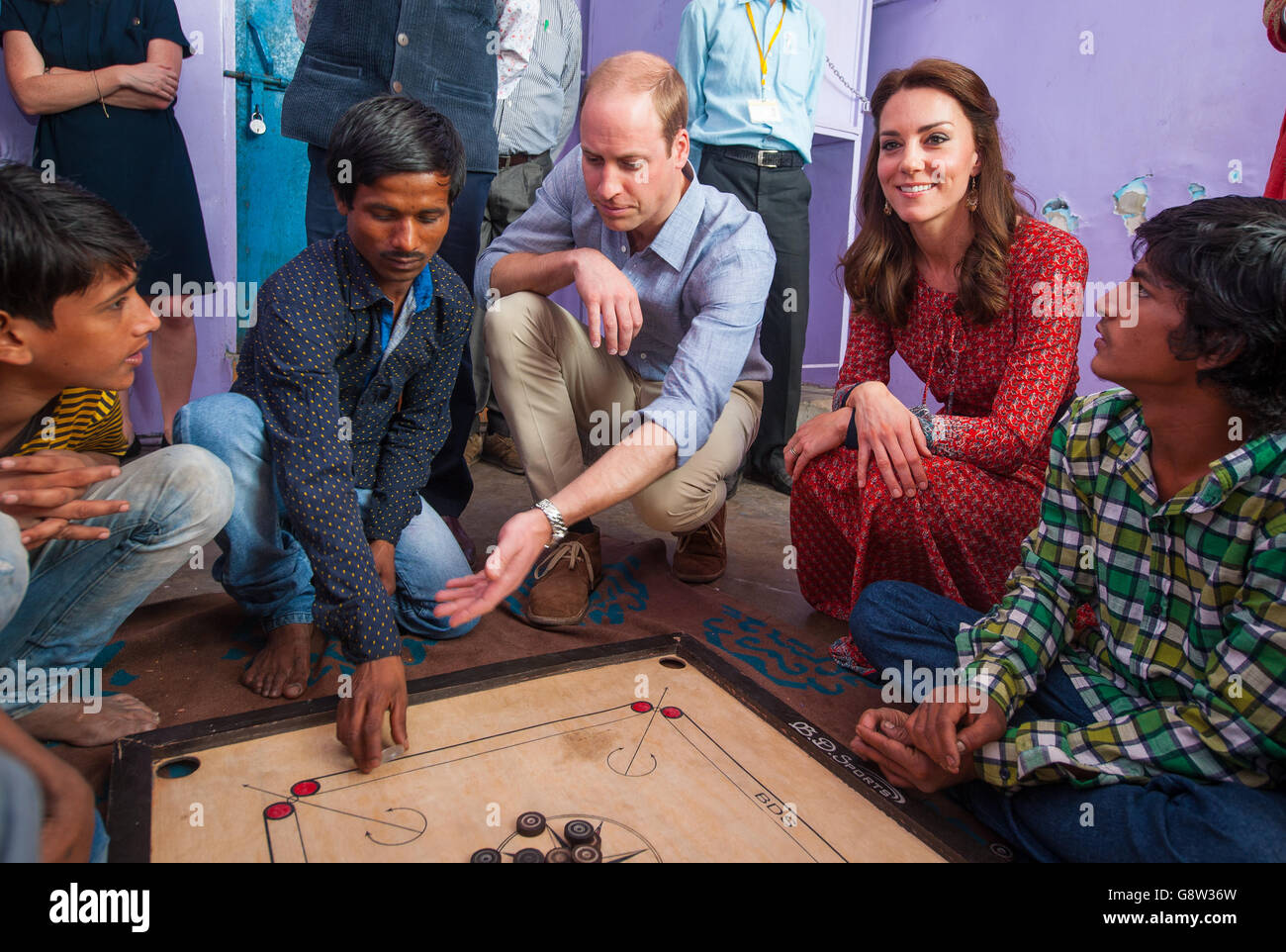 The Duke and Duchess of Cambridge play a game of carrom with street children at a contact centre run by the charity Salaam Baalak, which provides emergency help and long term support to homeless children at New Delhi railway station, India, during day three of the royal tour to India and Bhutan. Stock Photo