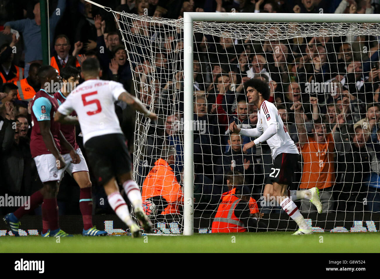 Manchester United's Marouane Fellaini (right) celebrates scoring their second goal of the game during the Emirates FA Cup, Quarter Final Replay match at Upton Park, London. Stock Photo