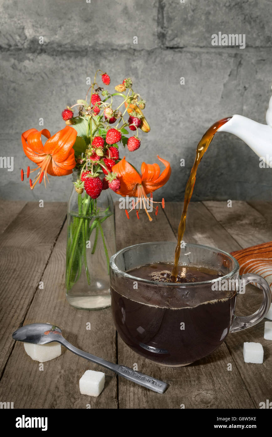 Strong tea is poured into a cup Stock Photo