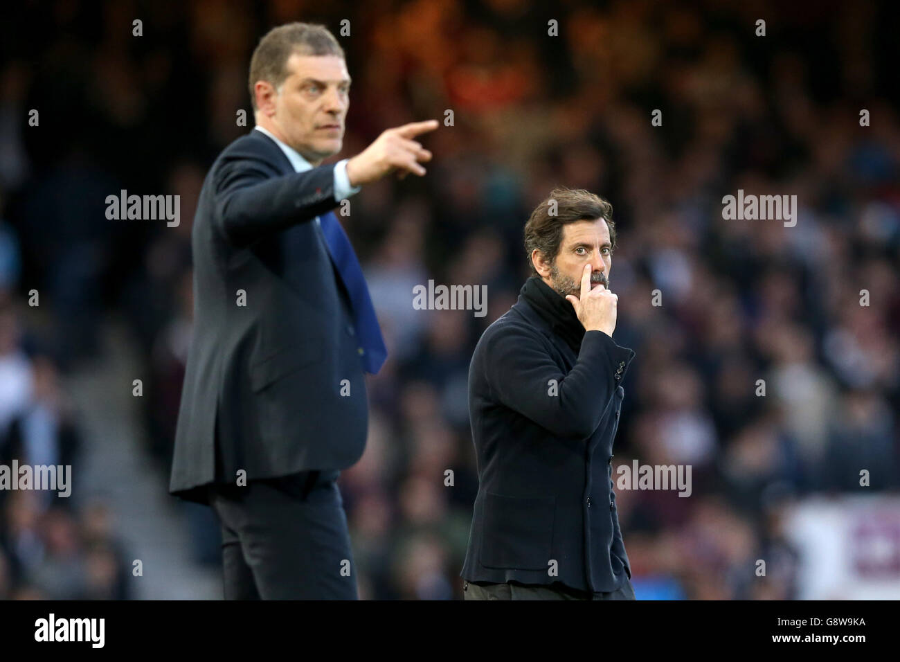 Watford manager Quique Sanchez Flores (right) scratches his nose and West Ham United manager Slaven Bilic (left) gestures on the touchline Stock Photo