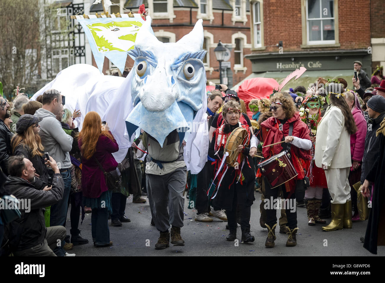 A white dragon costume proceeds through the crowds during the Glastonbury Beltane celebrations in Somerset, where the traditionally Gaelic May Day festival is celebrated annually on the 1st of May or halfway between the spring equinox and the summer solstice. Stock Photo