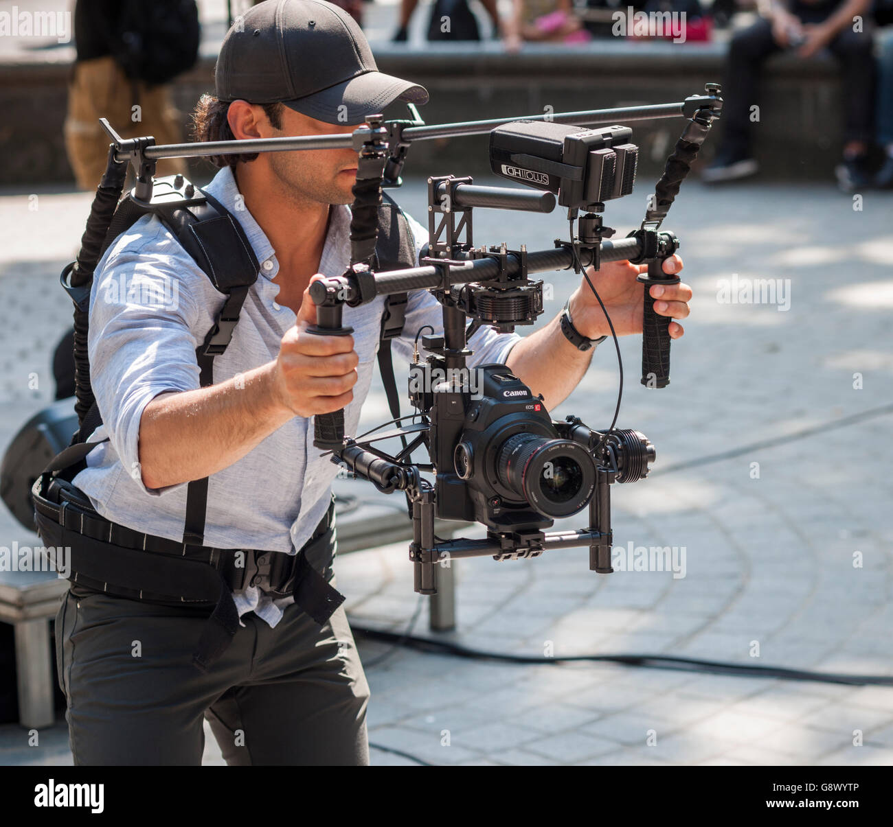 A videographer uses a Canon Eos C camera, on a stability rig with gimbal, in New York on Tuesday, June 21, 2016. (© Richard B. Levine) Stock Photo