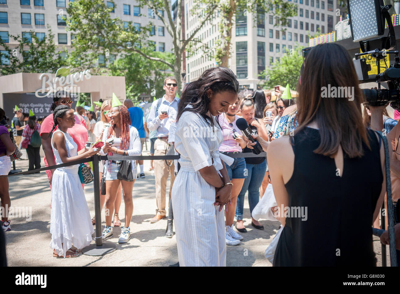 Actress/singer Kelly Rowland is interviewed in Madison Square Park in New York during the Breyers ice cream event on Wednesday, June 22, 2016. Breyers is giving away the summer treat as a celebration of the company's 150th anniversary. Besides the dessert visitors had the opportunity to meet various celebrities that Breyers had brought in. Breyers is a brand of the giant conglomerate Unilever. (© Richard B. Levine) Stock Photo