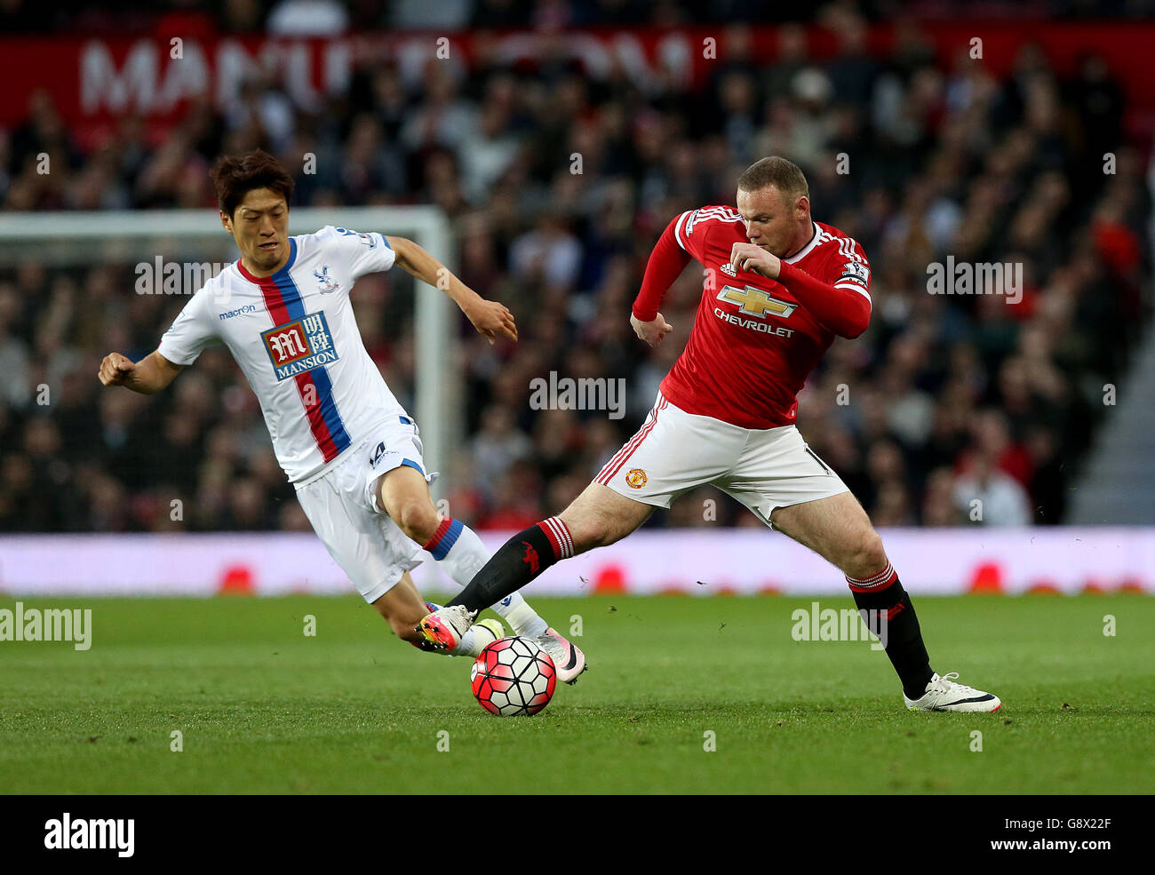Crystal Palace's Lee Chung-yong and Manchester United's Wayne Rooney battle for the ball during the Barclays Premier League match at Old Trafford, Manchester. Stock Photo