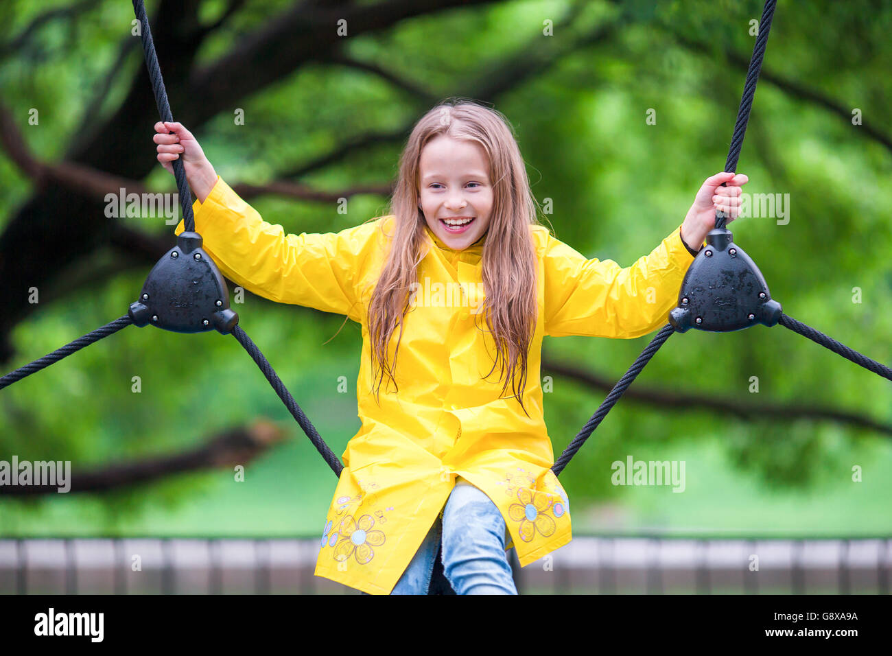 Happy little girl playng on outdoor playground Stock Photo - Alamy