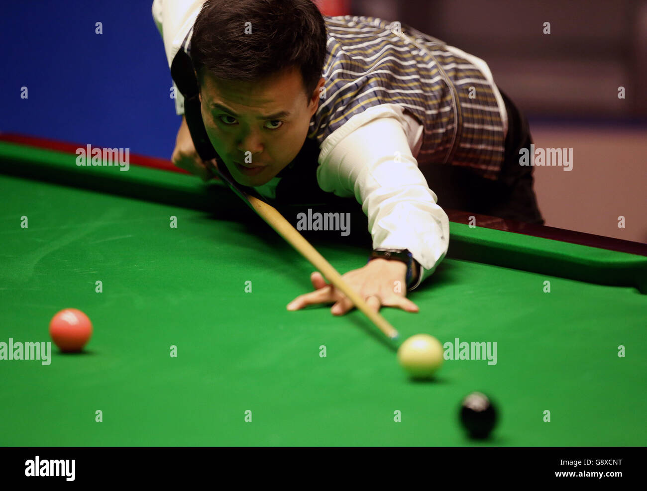 Marco Fu in action during day fifteen of the Betfred Snooker World Championships at the Crucible Theatre, Sheffield. Stock Photo