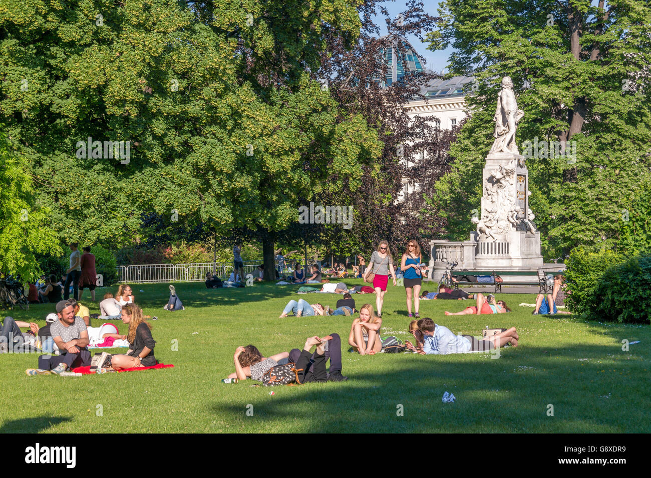 People relaxing near Mozart monument in Burggarten Gardens, Hofburg in downtown Vienna, Austria Stock Photo