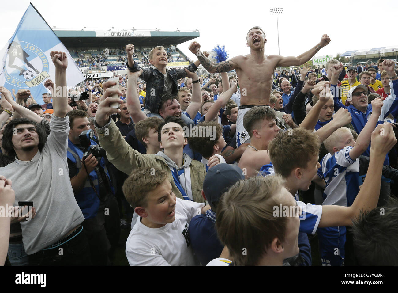 Bristol Rovers' Matt Taylor celebrates on the pitch with fans after