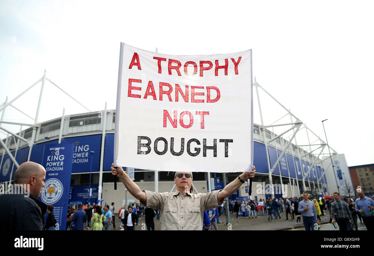 Leicester City Fans After Winning The 2015-16 Barclays Premier League. A Leicester City fan with a 'A trophy earned not bought' banner outside the King Power Stadium in Leicester. Stock Photo