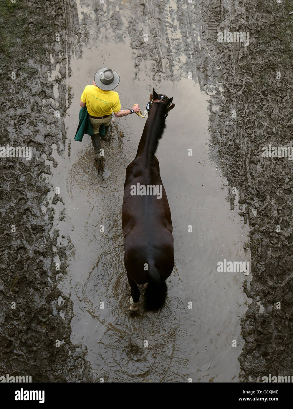 A horse is lead back from the showground after exercising during the first day of the Royal Windsor Horse Show at Windsor Castle in Berkshire, as torrential rain has resulted in the cancellation of one of the main celebrations marking the Queen's 90th birthday. Stock Photo