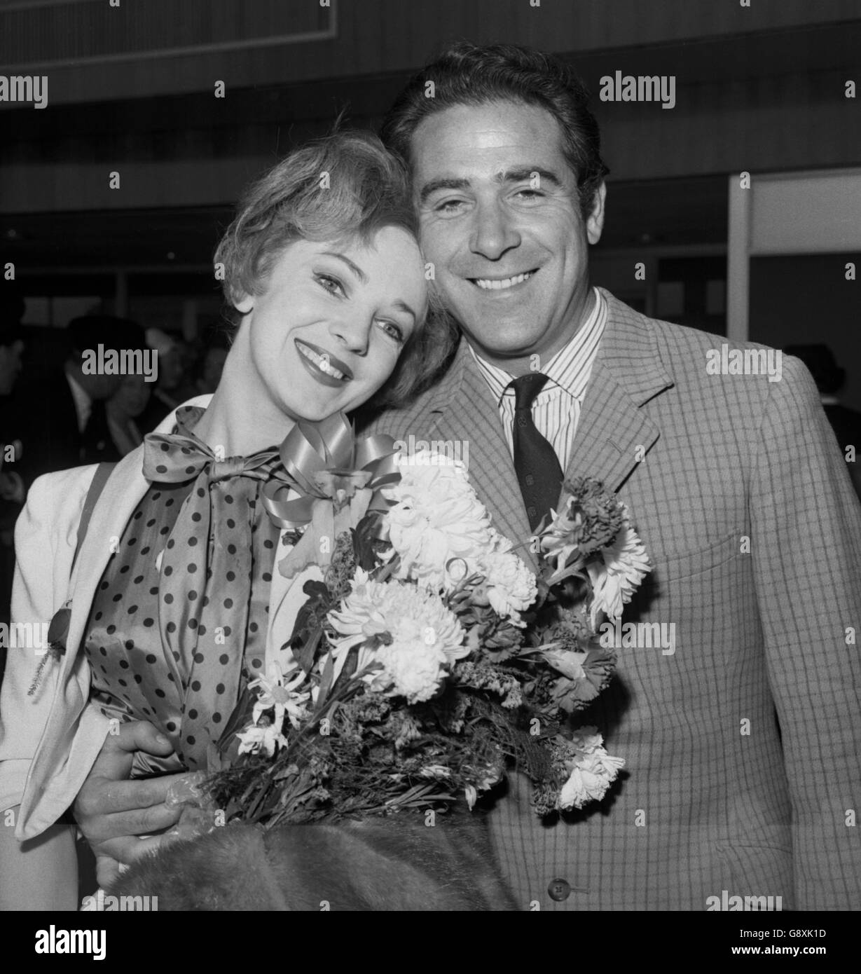 Actress and singer, Patricia Bredin, who has given up her starring role in the Broadway show 'Camelot' to make preparations to marry Ivor Emmanuel, is met by the 32-year-old Welsh singer on her arrival at London Airport. Stock Photo