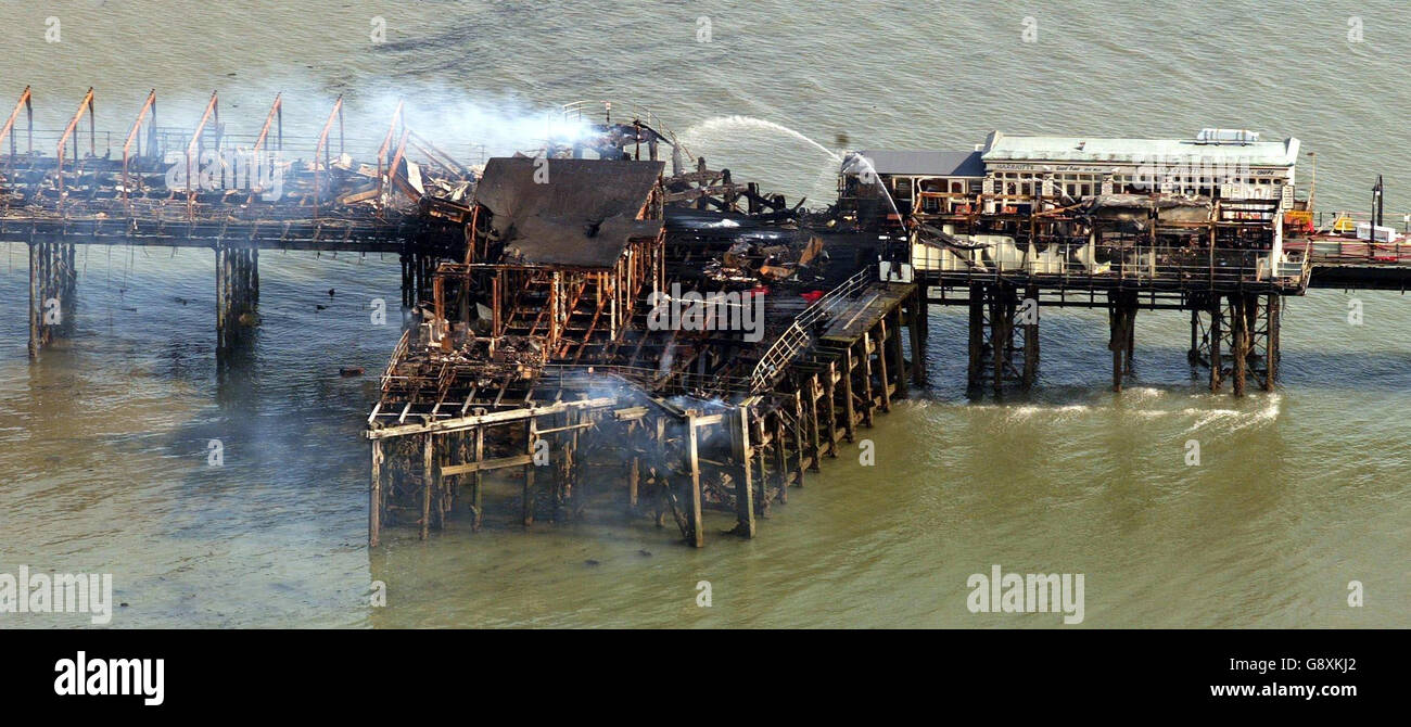 Southend pier smoulders following a fire Monday October 10, 2005. The world's longest pleasure pier will be rebuilt after it was gutted by a massive blaze, town officials pledged today. Southend Borough Council leader Anna Waite estimated it would cost millions to rebuild. See PA story FIRE Pier. PRESS ASSOCIATION Photo. Photo credit should read: Gareth Fuller/PA. Stock Photo