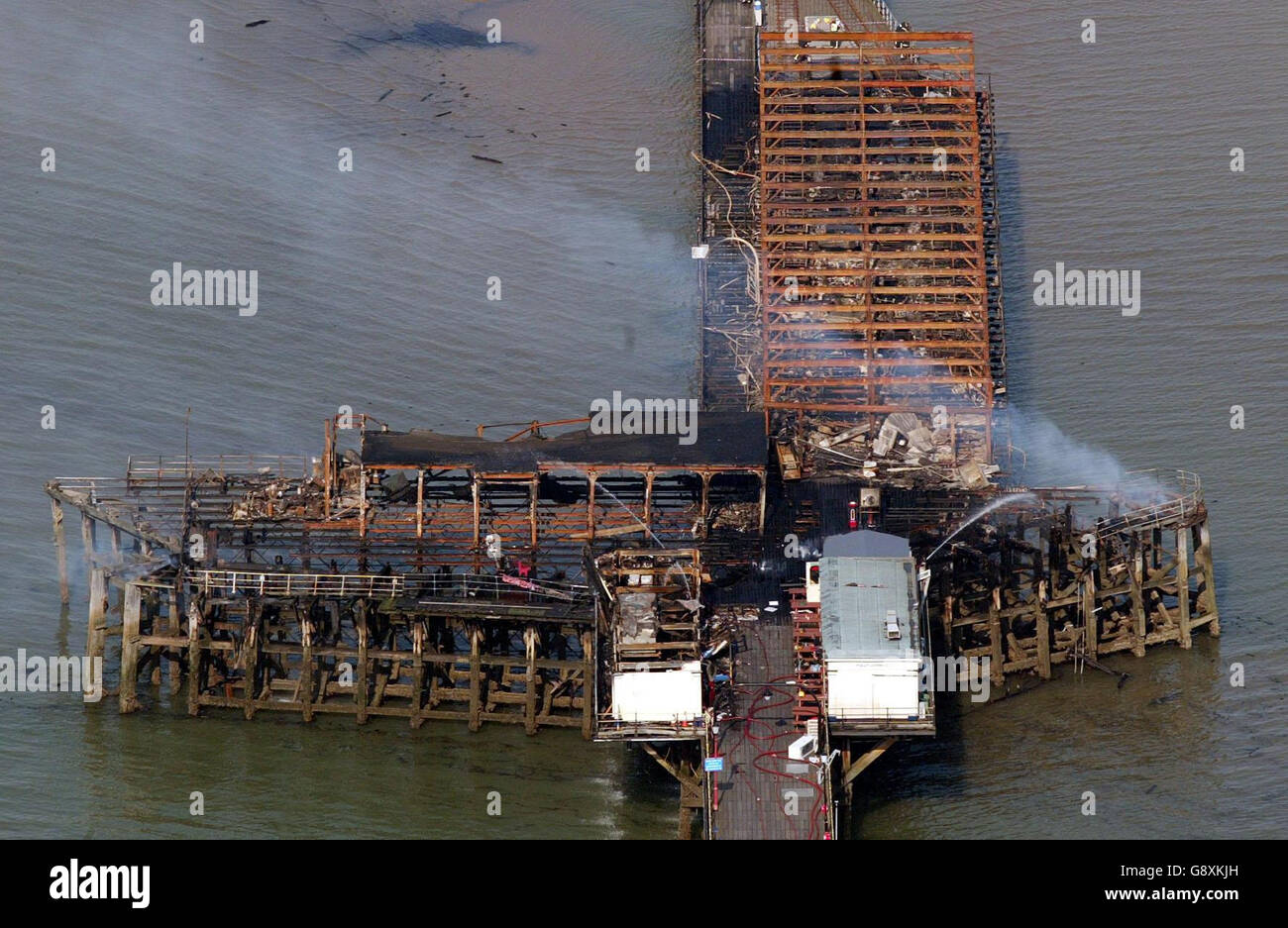 Southend pier smoulders following a fire Monday October 10, 2005. The world's longest pleasure pier will be rebuilt after it was gutted by a massive blaze, town officials pledged today. Southend Borough Council leader Anna Waite estimated it would cost millions to rebuild. See PA story FIRE Pier. PRESS ASSOCIATION Photo. Photo credit should read: Gareth Fuller/PA. Stock Photo