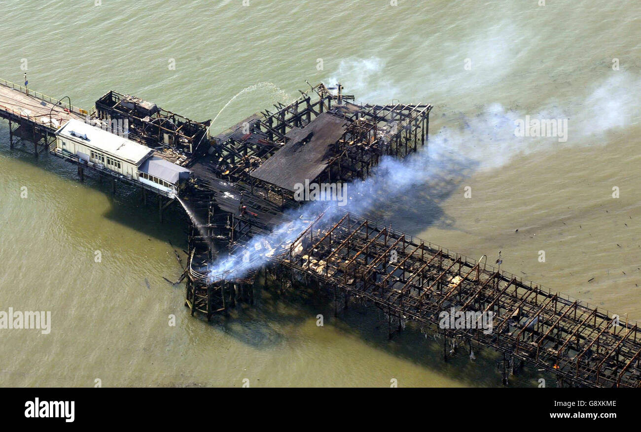 Southend pier smoulders following a fire Monday October 10, 2005. The world's longest pleasure pier will be rebuilt after it was gutted by a massive blaze, town officials pledged today. Southend Borough Council leader Anna Waite estimated it would cost millions to rebuild. See PA story FIRE Pier. PRESS ASSOCIATION Photo. Photo credit should read: Gareth Fuller/PA. Stock Photo