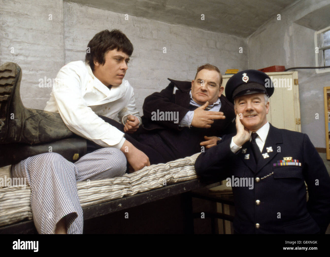 Old lag Fletcher (Ronnie Barker), fellow prisoner Godber (Richard Beckinsale) and prison officer Mackay (Fulton Mackay) during location shooting for the film version of their TV series 'Porridge' at Chelmsford Jail, which has been empty since a fire last year. Stock Photo