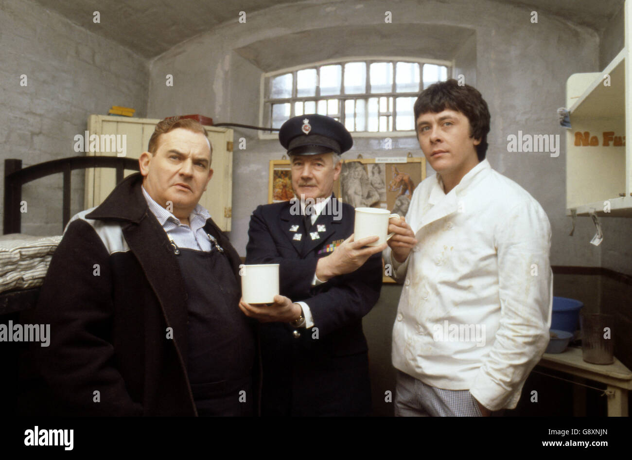 Old lag Fletcher (Ronnie Barker), fellow prisoner Godber (Richard Beckinsale) and prison officer Mackay (Fulton Mackay) during location shooting for the film version of their TV series 'Porridge' at Chelmsford Jail, which has been empty since a fire last year. Stock Photo