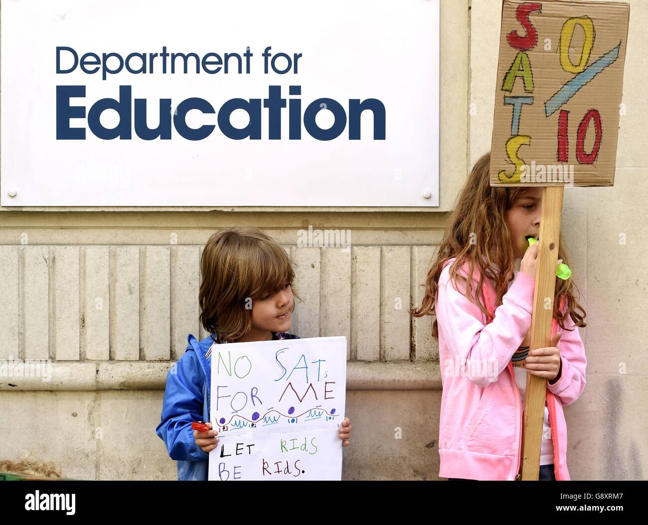 Emiliano and nine-year-old Rosie hold signs outside the Department of Education in London, as they protest with their parents at controversial Sats tests for six and seven-year-olds. Stock Photo