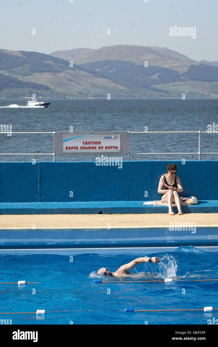 Swimmers and sunbathers enjoy the hot weather at Gourock Outdoor Pool, a heated salt water lido in Gourock, Renfrewshire. Stock Photo