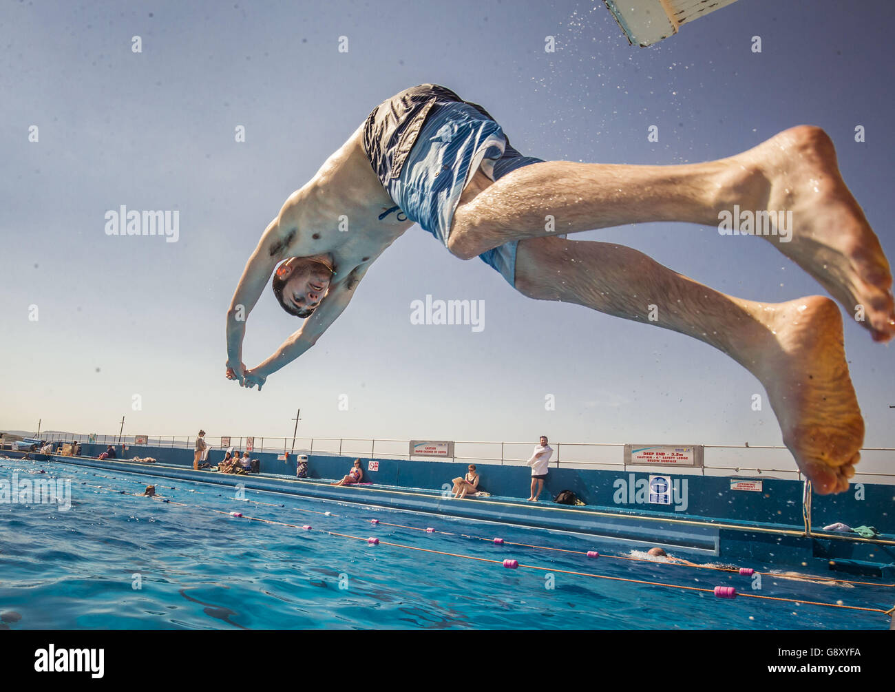 Swimmers and sunbathers enjoy the hot weather at Gourock Outdoor Pool, a heated salt water lido in Gourock, Renfrewshire. Stock Photo