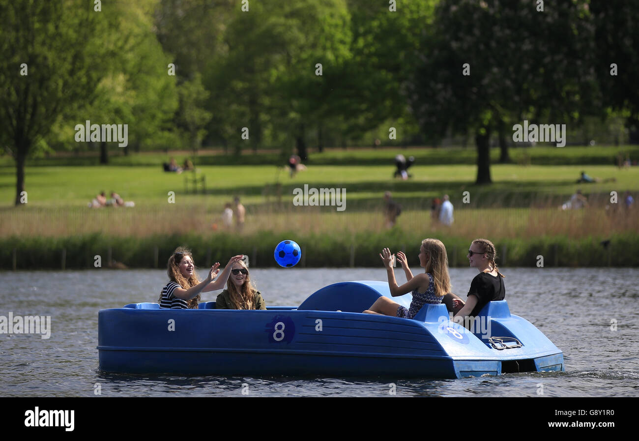 Visitors to Hyde Park ride paddle boats along the Serpentine, London