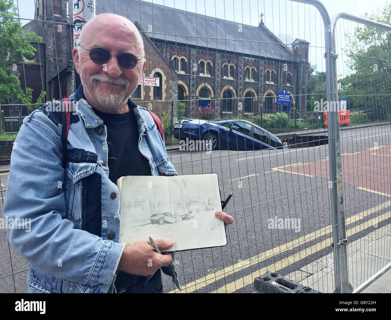 Brian Bath, 63, with his sketch of the scene on Woodland Terrace in Greenwich where a sinkhole partially swallowed a car. Stock Photo