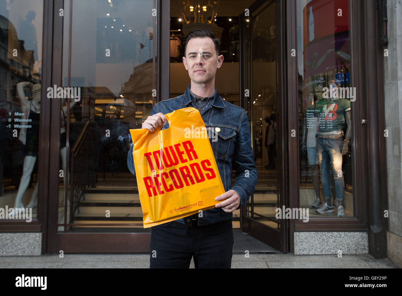 Colin Hanks holding a Tower Records bag at Piccadilly Circus in London, the star of The Good Guys and Fargo, makes his directorial debut with All Things Must Pass, a film that tells the story of Tower Records and features Sir Elton, Foo Fighters frontman Dave Grohl and singer Bruce Springsteen. Stock Photo